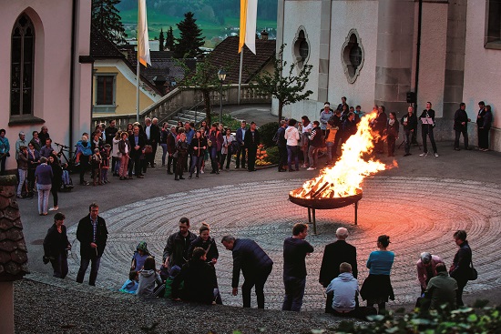 Angezündetes Osterfeuer in Feuerschale auf Kirchplatz